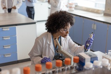 Female scientist pipetting in laboratory 