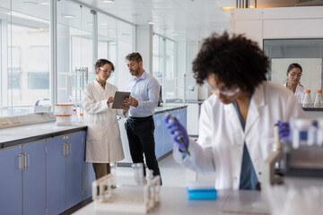 Scientists discussing data using a digital tablet in a laboratory