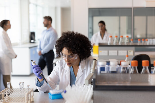 Female science student pipetting in laboratory 