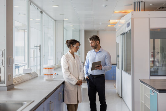 Scientists discussing data using a digital tablet in a laboratory