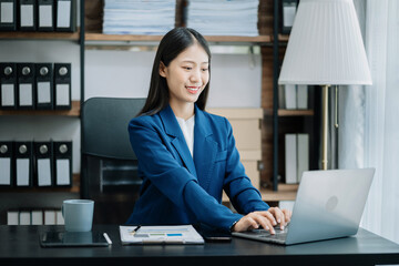 Businesswomen hand working with tablet and laptop computer with documents on office desk in modern office.