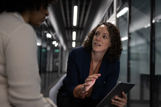 Businesswoman in a meeting with a coworker working late in the office