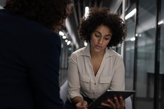 Businesswoman in a meeting with a coworker working late in the office - Powered by Adobe