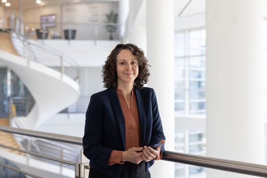 Businesswoman holding a smartphone in modern corporate office atrium