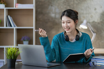 Asian female high school student learning and watching online course on laptop at home. Young female student studying in online classroom with teacher at home