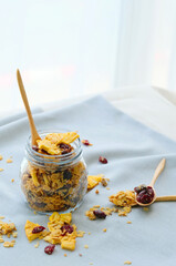 glass jar with homemade granola, nuts, pineapple and  berries