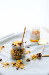 glass jar with homemade granola, nuts, pineapple and  berries
