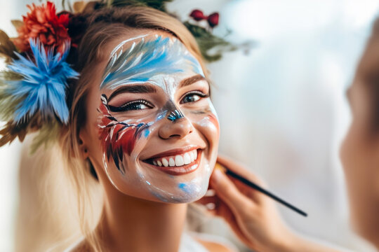 Smiling woman having her face painted.