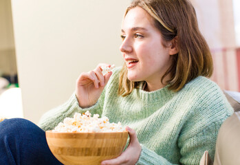 pretty young woman with a popcorns bowl.. house interior design