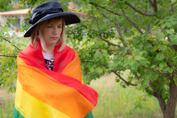 A woman with an LGBT flag on her face. Young crying woman with LGBT flag on her cheek. The concept...