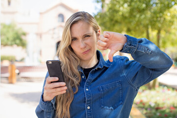 feeling cross,showing thumbs down. smartphone concept