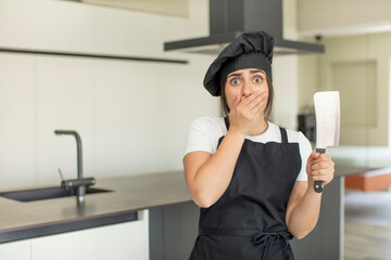 Fototapeta na wymiar young woman covering mouth with a hand and shocked or surprised expression. chef concept