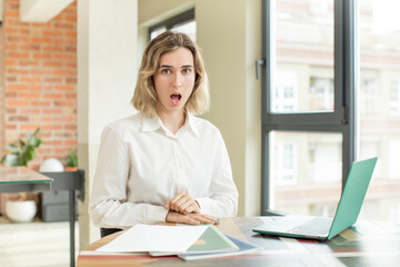 pretty woman feeling extremely shocked and surprised. home work telecommuting concept