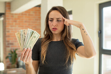 pretty woman looking surprised, realizing a new thought, idea or concept. dollar banknotes concept