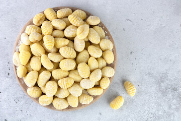 Uncooked italian potato gnocchi on gray background. Top view. Italian food.