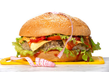 Hamburger wrapped in a measuring tape on a white background. Weight loss concept.