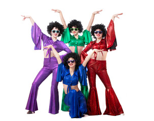 A group of girls in colorful flared suits and afro wigs pose against a white background. Disco...