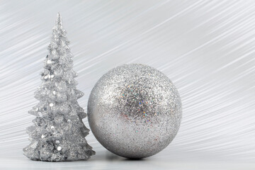 Christmas or New Year background with silver snowy tree and silver transitional decoration. Bright festive background.