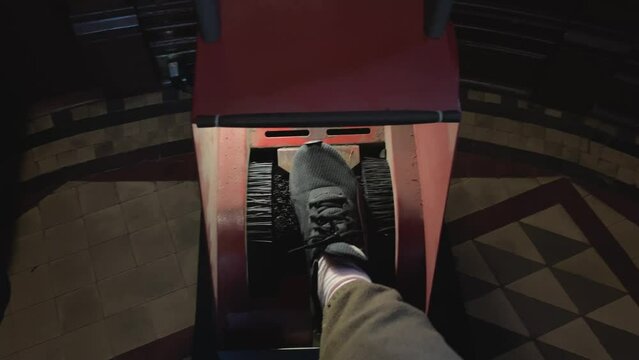 a special machine for cleaning shoes at the entrance iron apparatus people insert their feet in shoes in sneakers, she throws dirt off 