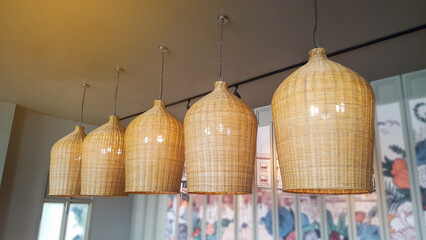 Woven bamboo strips lamps hanging from the ceiling with blurred background