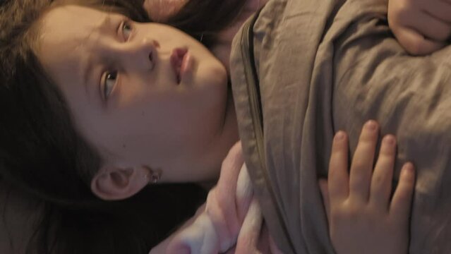 Vertical video. Kid bed fear. Night terror. Scared frightened disturbed small girl afraid of spooky noise alone hiding under blanket.