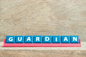 Obraz premium Tile alphabet letter with word guardian in red color rack on wood background