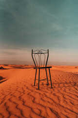 Chair in desert: An intriguing sight, a lone chair stands amidst the barren expanse, a silent enigma that sparks curiosity and imagination.