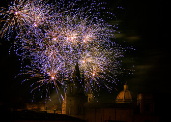Naklejka premium Fuochi d'artificio colorati nel cielo notturno sopra la cattedrale di Acireale 