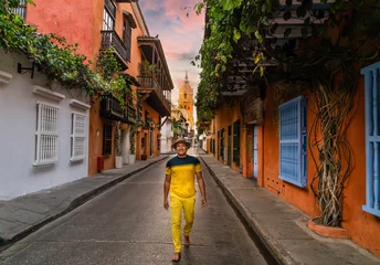 Foto op Canvas afro colombian man walk in cartagena colombia street with church and flower balcony in old colonial city © Blogtrip