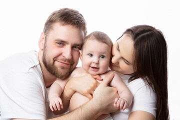 Close up portrait of young parents and baby. Father and mother kiss and hug a beautiful little son. The concept of love, happy fatherhood and motherhood.