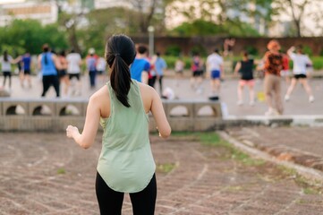 Female jogger. Fit young Asian woman with green sportswear aerobics dance exercise in park and...