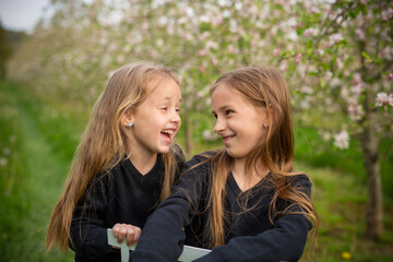 Fototapeta premium Portrait of two sisters, one hugging the other