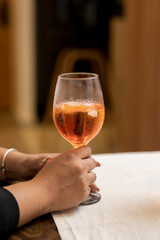 Woman's hands holding a glass of wine with a cocktail
