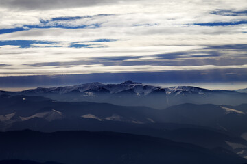 Fototapeta na wymiar Silhouettes of cloudy mountains in evening