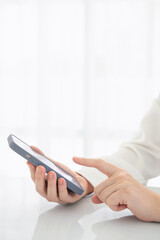 Woman with a finger on the screen using a mobile phone in the office