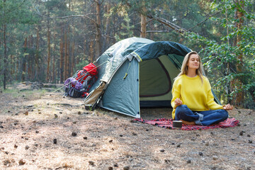 Breath with the morning forest and free your mind with meditation. Young woman is meditating in a...