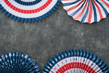 4th of July background. USA paper fans, Red, blue, white stars, balloons, gold confetti on gray...