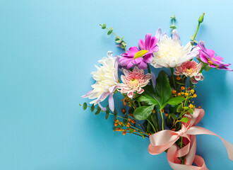 Bouquet of beautiful spring flowers on pastel blue table top view Greeting card. Close up. Generative AI
