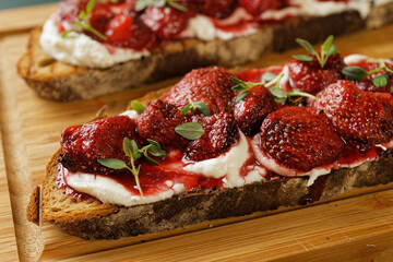 Baked strawberries with honey and thyme atop ricotta-slathered toast.