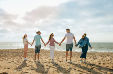 Glad millennial european and arab people in casual hold hands, enjoy vacation, freedom, team building