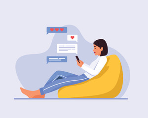 girl sits in a bag chair and sends a message