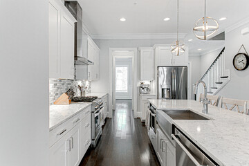 Clean Spring Modern White Kitchen Interior with Stylish Backsplash and Deep Steel Sink and Metal Pendant Lights