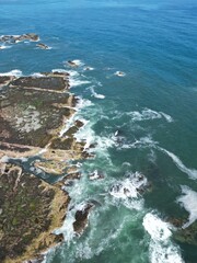 Aerial top down view of waves crashing onto the rocks off the coastline of Dunbar Scotland. 