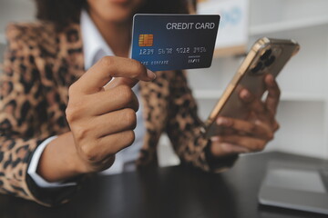 Women holding credit card and using smartphones at home.Online shopping, internet banking, store online, payment, spending money, e-commerce payment at the store, credit card, concept