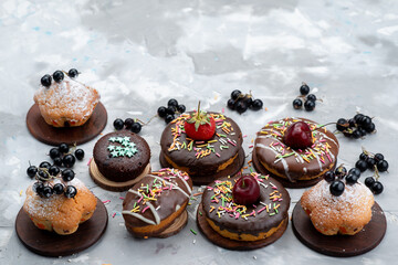 a top view cakes and donuts chocolate based with fruits and candies on the grey background cake biscuit sweet
