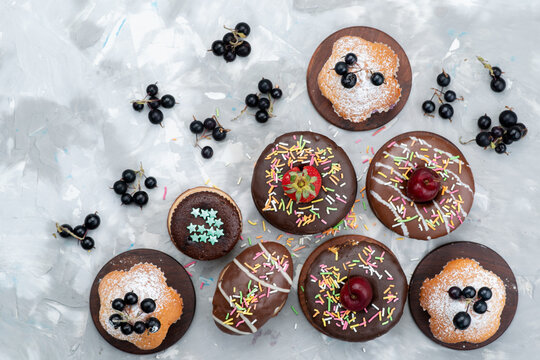 a top view cakes and donuts chocolate based with fruits and candies on the grey background cake biscuit sweet sugar