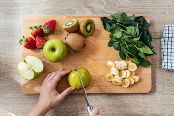 Woman hands cutting fruits and vegetables in the kitchen at home