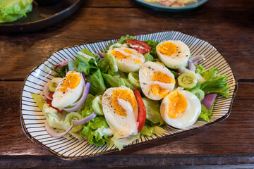 Stir fried mixed salad with boiled egg and sauce, Healthy food in ceramid plate