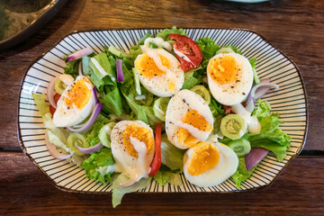 Stir fried mixed salad with boiled egg and sauce, Healthy food in ceramid plate