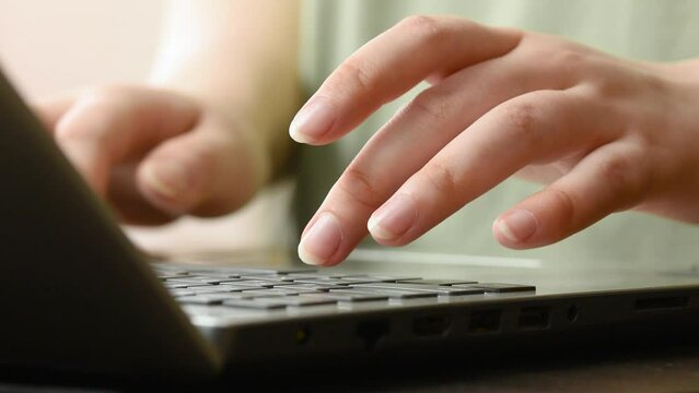 female hands typing text on the keyboard